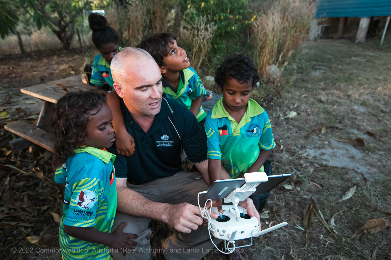 Lama Lama TUMRA and children learning a drone setup - Commonwealth of Australia (Reef Authority)