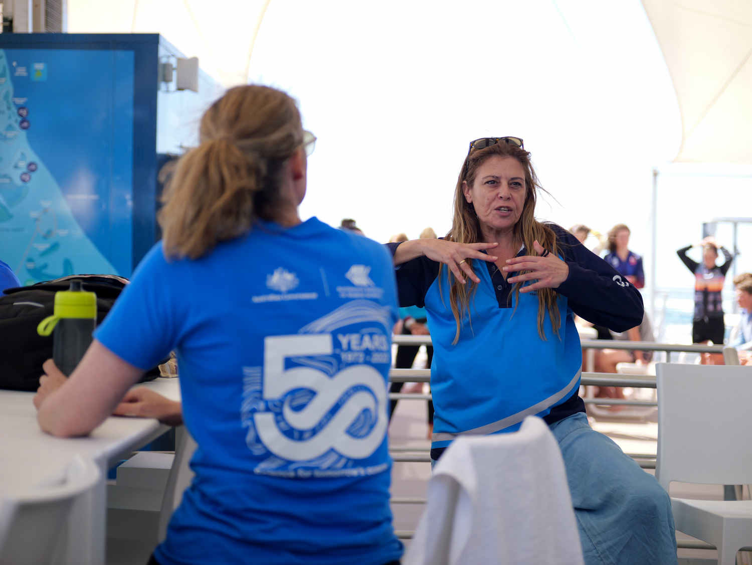 Two people speaking on board large reef boat