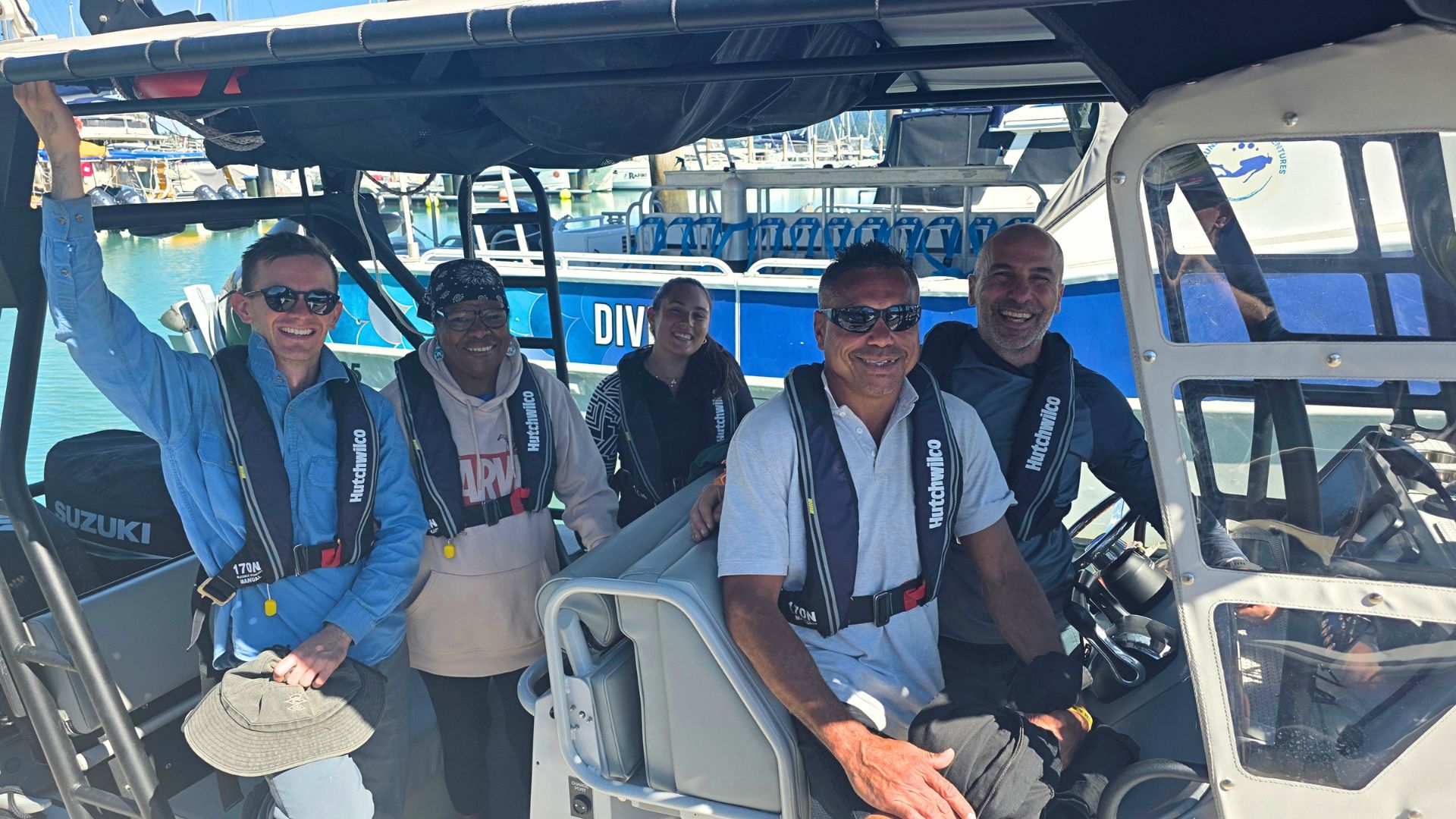 Three researchers and two Traditional Owners on a research boat in the Whitsundays