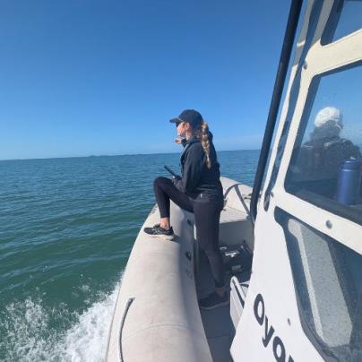 Member of the research team stands at the bow of the boat