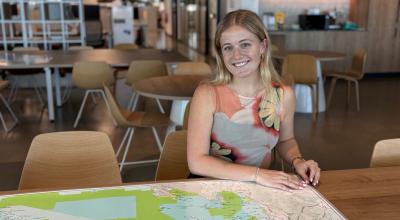 A woman sits at a table with a map on it